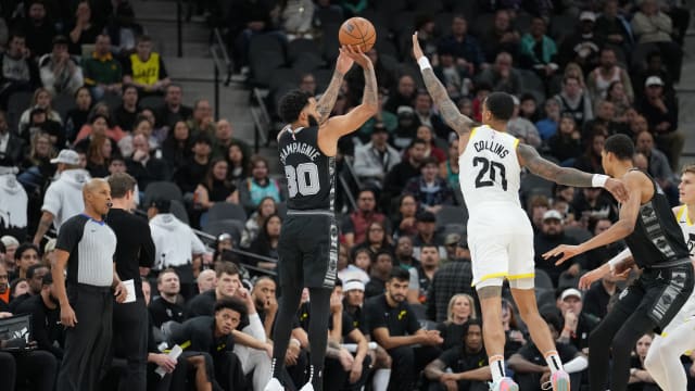 Dec 26, 2023; San Antonio, Texas, USA; San Antonio Spurs forward Julian Champagnie (30) shoots over Utah Jazz forward John Collins (20) in the first half at the Frost Bank Center.